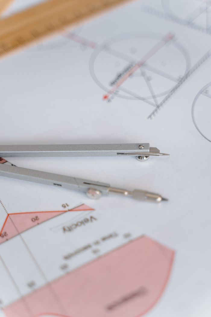 A close-up of a compass on geometric drawing paper, ideal for education and mathematics concepts.